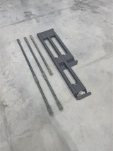 The three-bar frame and its support bars laid out on a concrete floor