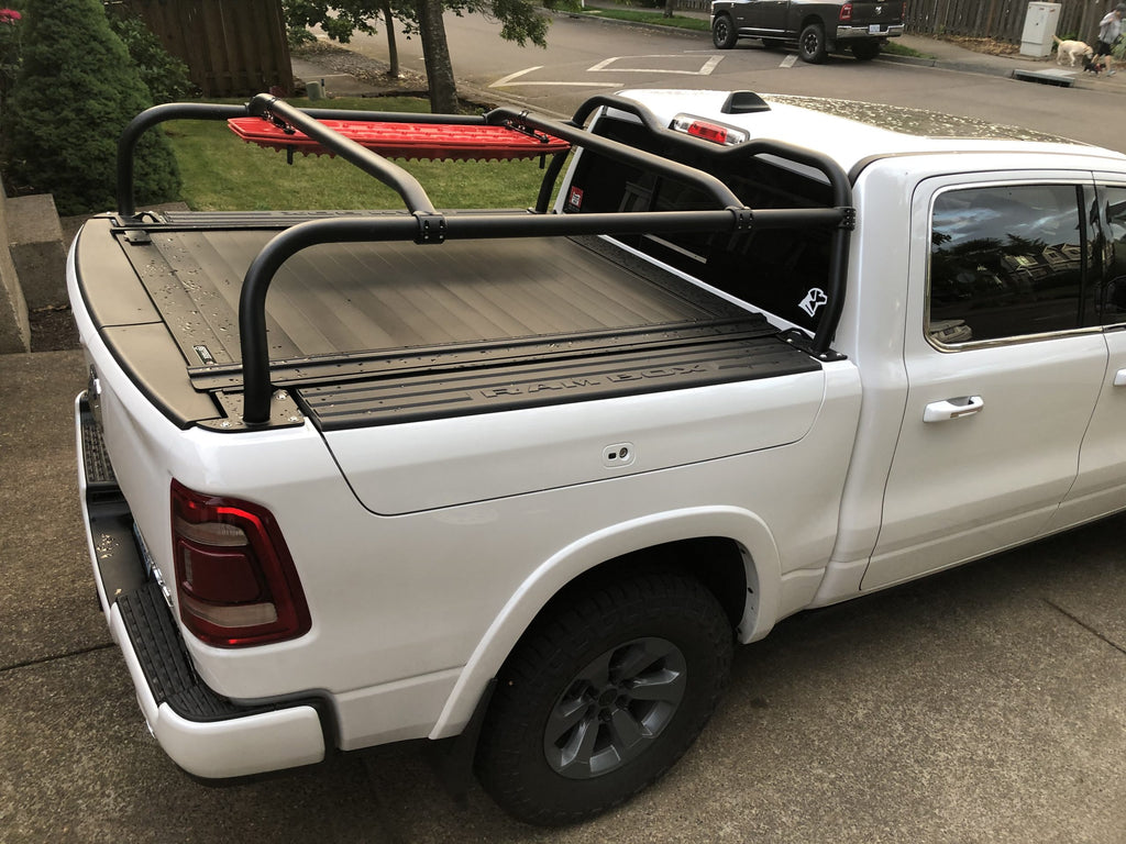 Looking across the bed of a white Ram, crossbars spanning a closed tonneau