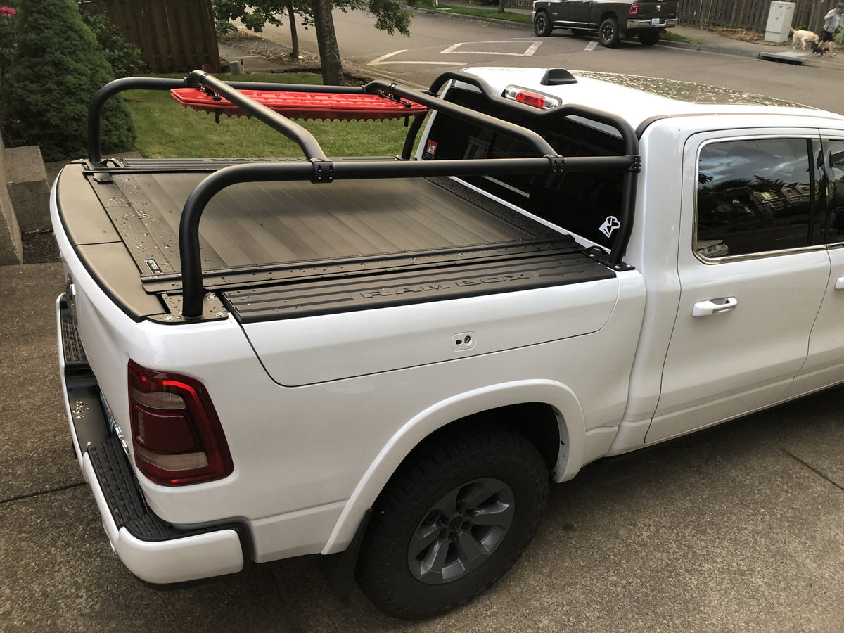 Looking across the bed of a white Ram, crossbars spanning a closed tonneau