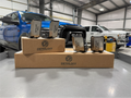 Four guards and a Dethloff box arranged on a bench, trucks in the shop behind