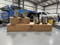 Four guards and a Dethloff box arranged on a bench, trucks in the shop behind