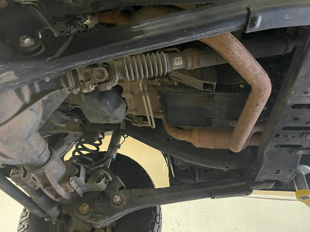 Under the truck with the plate fitted, steering rack and sway bar running above it
